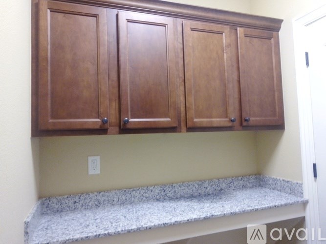 A kitchen with wooden cabinets and a granite countertop.
