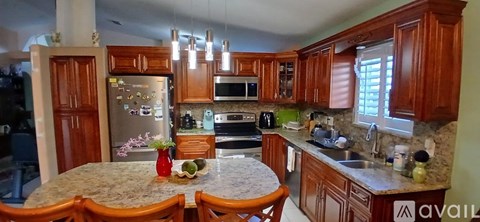 A kitchen with wooden cabinets and a granite countertop.
