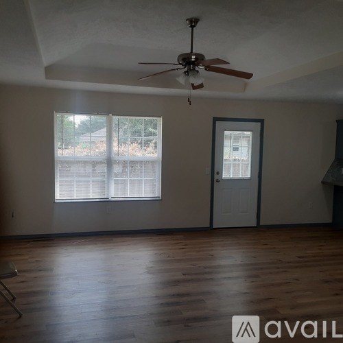 A room with a ceiling fan and a door.