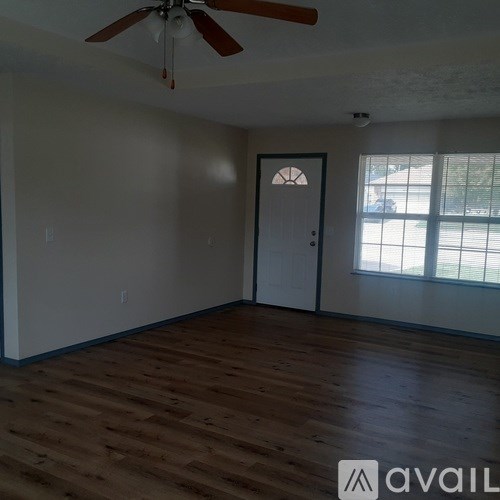 A room with a ceiling fan and a door.