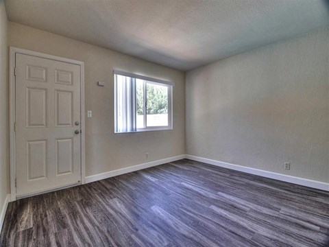 an empty living room with a door and a window