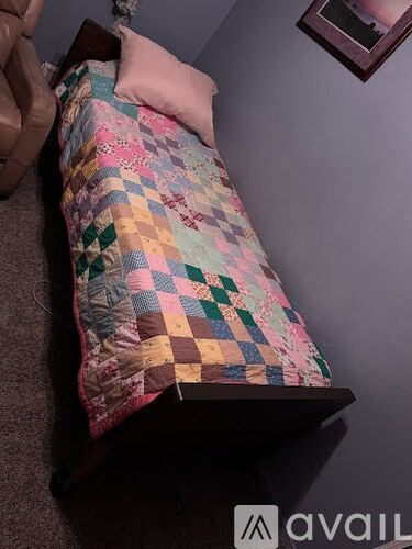 A person is holding a quilt with a patchwork design.