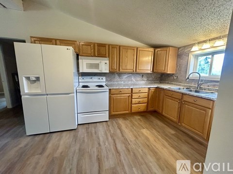 A kitchen with wooden cabinets and a white fridge.