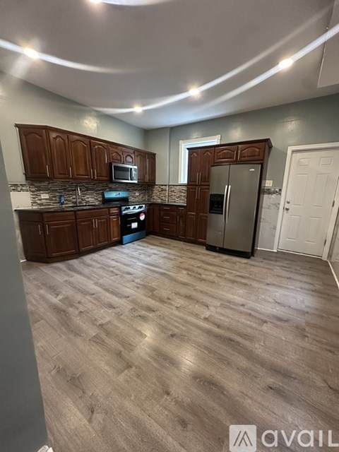 A kitchen with wooden cabinets and a refrigerator.