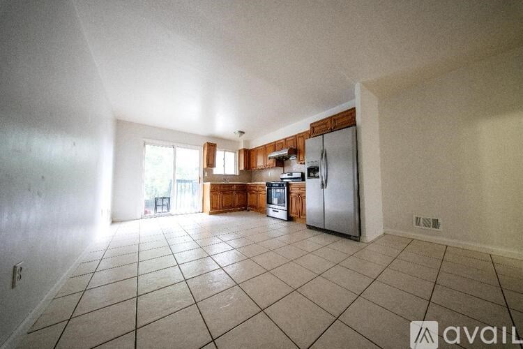A kitchen with a refrigerator, sink, and cabinets.
