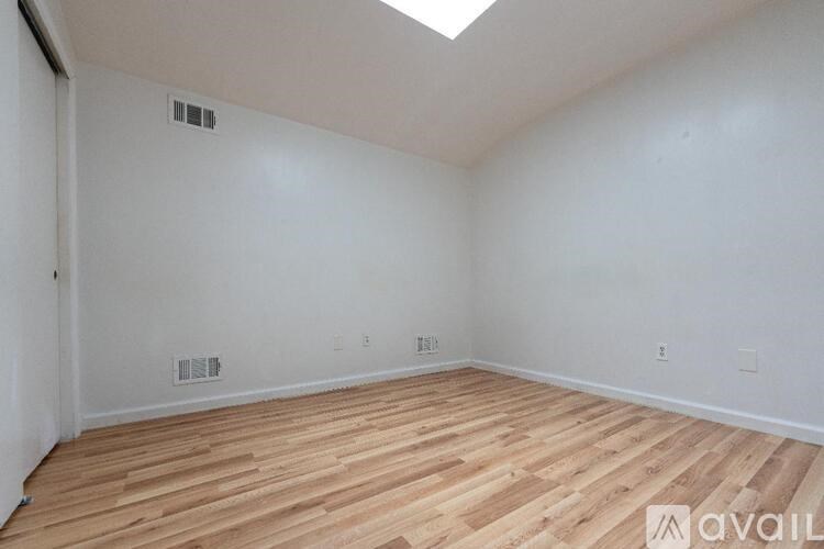 A room with wooden flooring and a skylight.