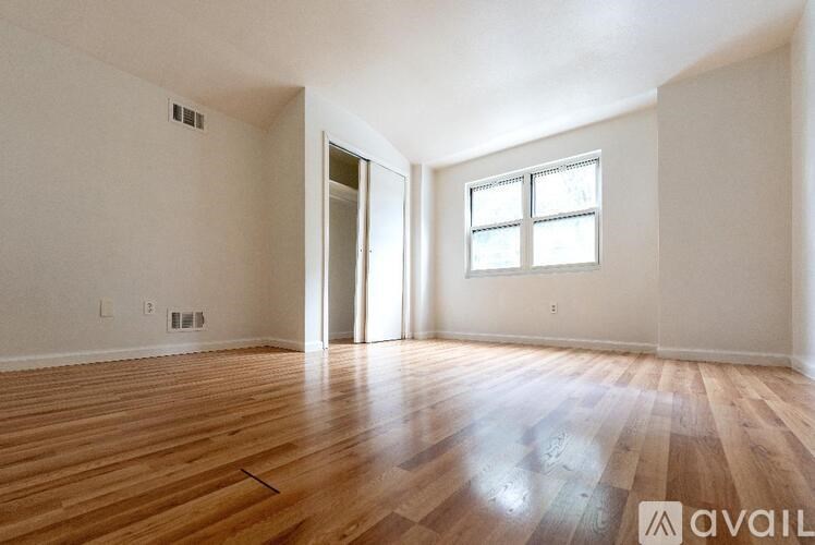 A room with wooden flooring and a window.