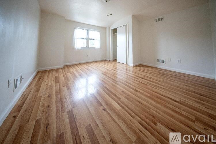 A room with wooden flooring and a window.