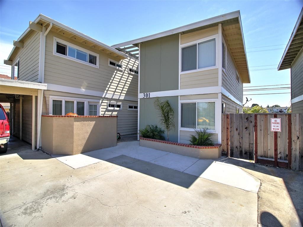 the front of a house with a driveway and a parking lot