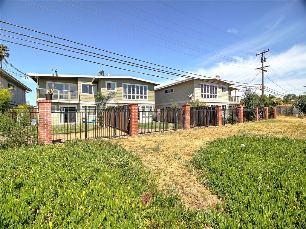 a row of houses behind a fenced in yard
