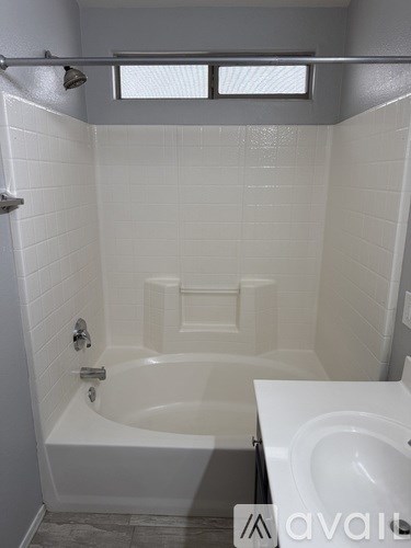 A white bathroom with a tub and toilet.