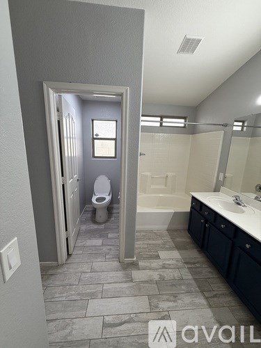 A bathroom with a toilet, sink, and bathtub.