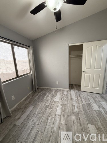 A room with a ceiling fan and a door.