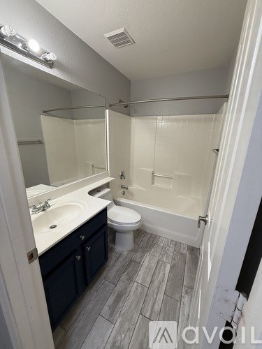 A bathroom with a toilet, sink, and bathtub.