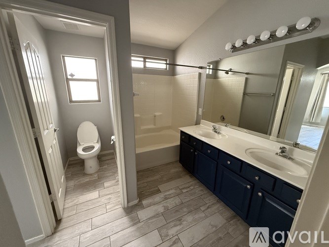 A bathroom with a toilet, sink, and mirror.