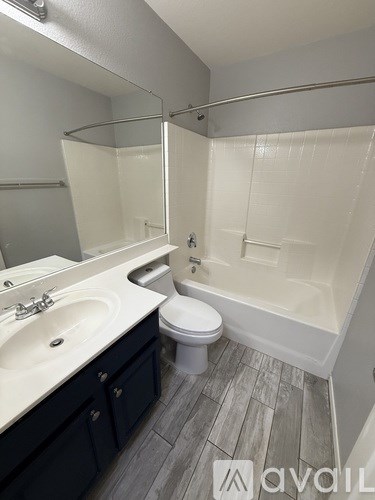 A bathroom with a toilet, sink, and bathtub.