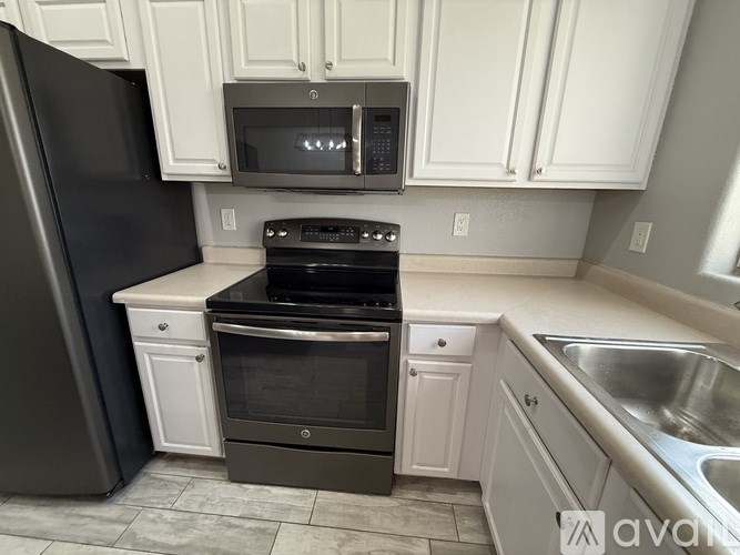 A kitchen with a black refrigerator, stove, and oven.