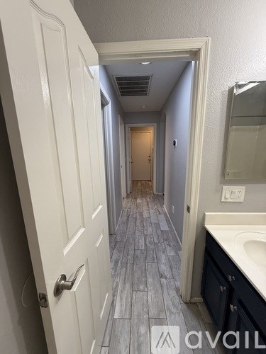 A hallway with a white door and a tiled floor.