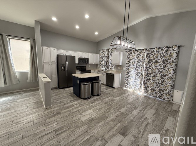 A modern kitchen with a refrigerator, oven, and sink.