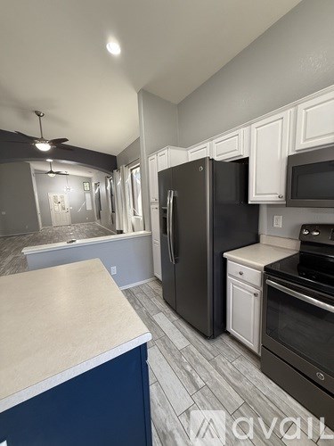 A kitchen with a black refrigerator and a white counter.
