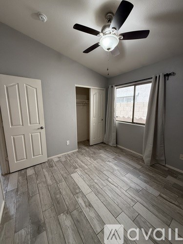 A room with a ceiling fan and a door.