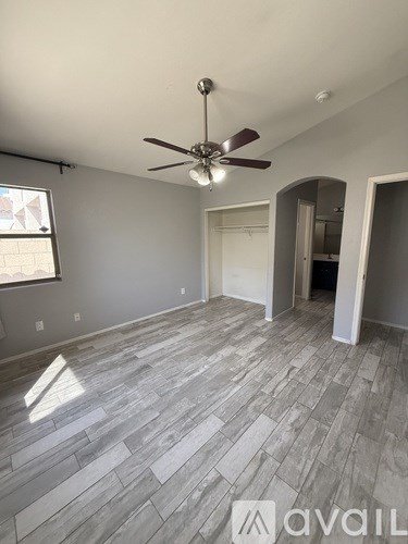 A room with a ceiling fan and a window.