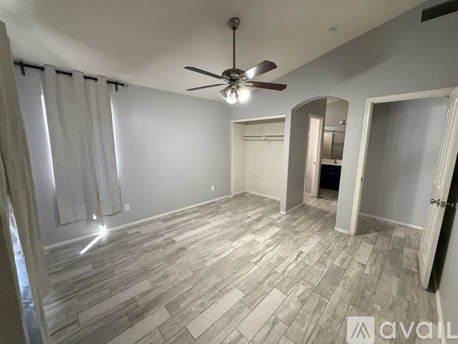 A room with a ceiling fan and a tiled floor.