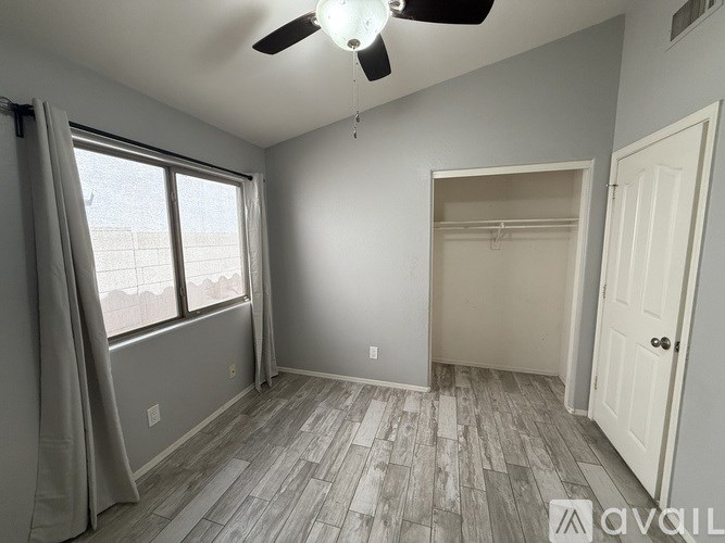 A room with a ceiling fan and a door.