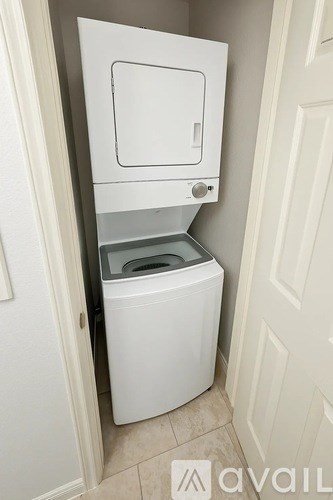 A white compact toilet is installed in a small bathroom.