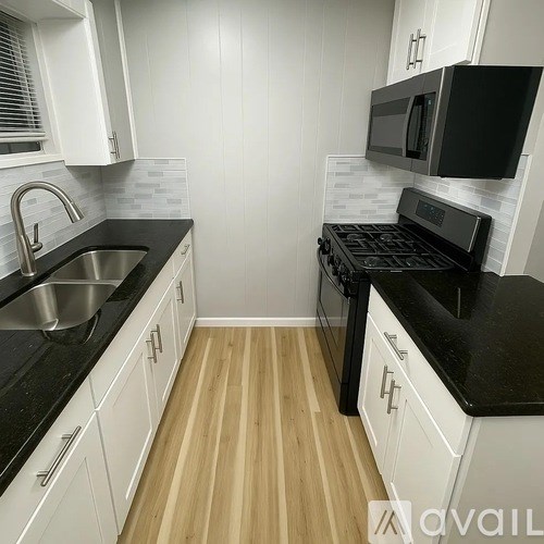 A kitchen with black countertops and white cabinets.