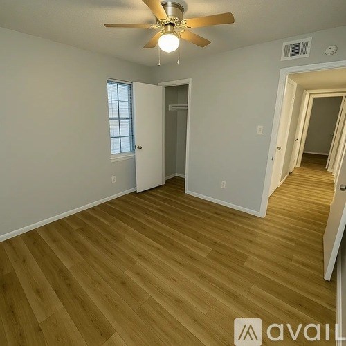 A room with wooden flooring and a ceiling fan.