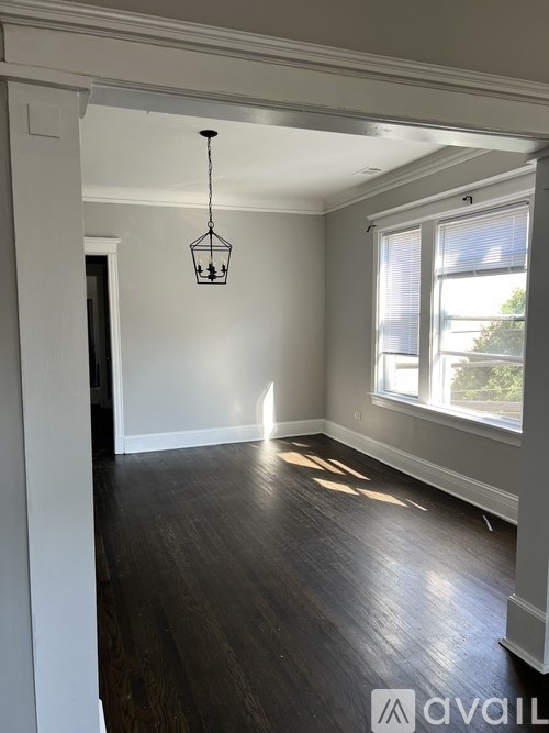 A room with a wooden floor and a hanging light fixture.