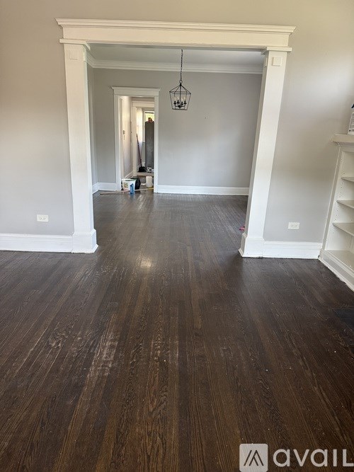 A hallway with wooden floors and white walls.