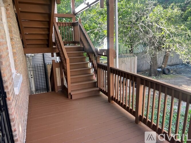 A wooden deck with a staircase leading to a balcony.