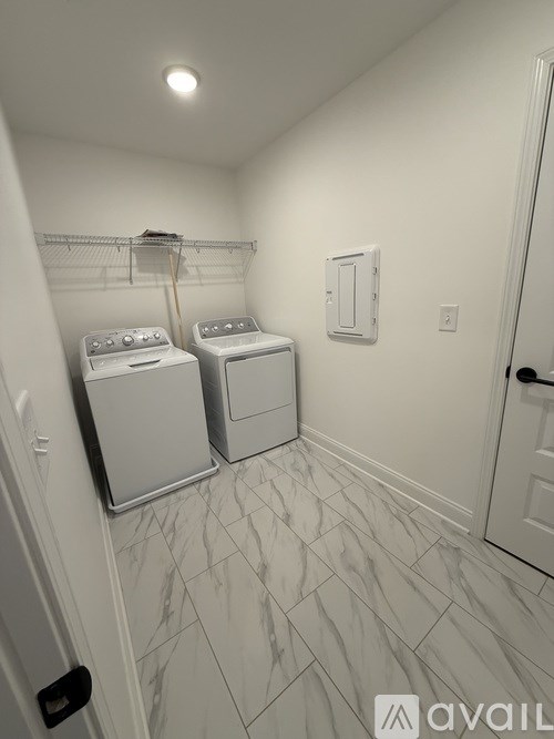 A laundry room with two washing machines and a white door.
