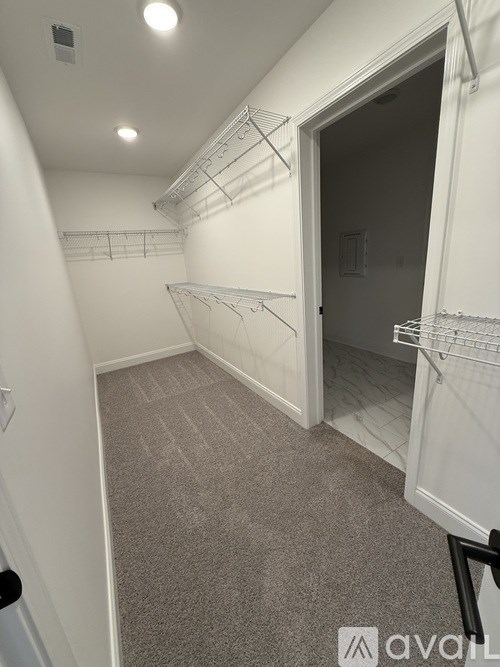 A room with a carpeted floor and a doorway leading to another room.