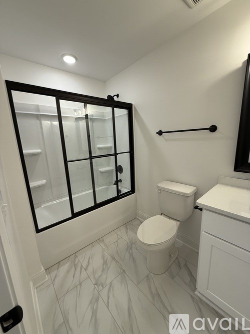 A white toilet in a bathroom with a glass door.