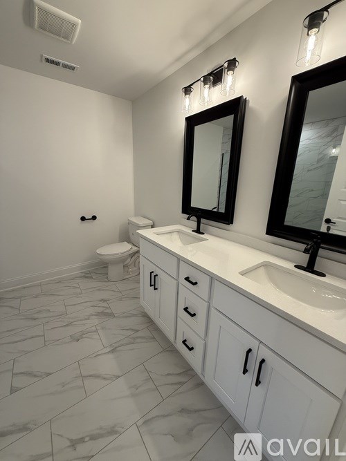 A bathroom with a toilet, sink, and mirror.