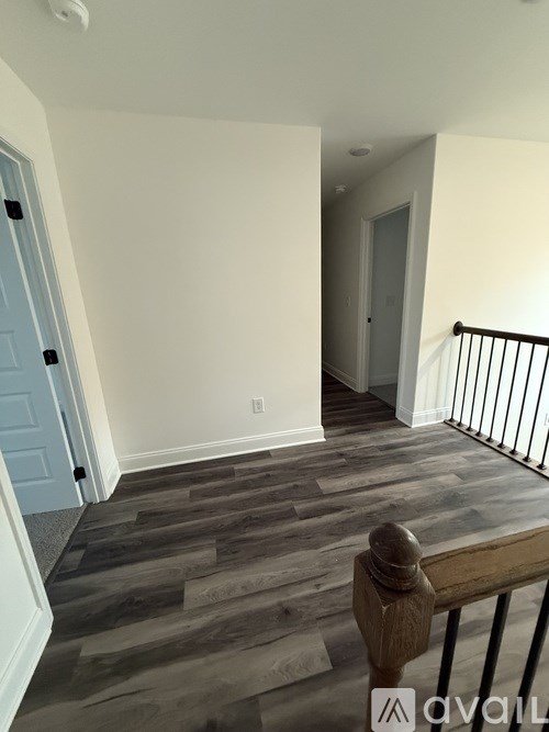 A room with a wooden floor and a white wall.