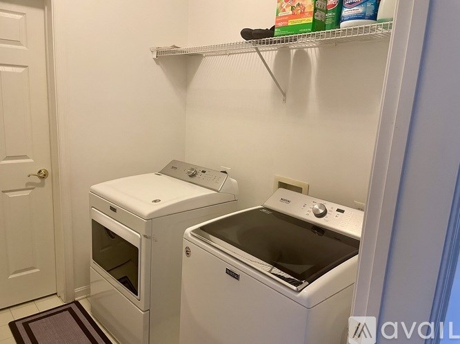 A white oven and microwave are on a shelf in a kitchen.