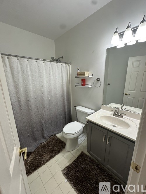 A bathroom with a toilet, sink, and shower.