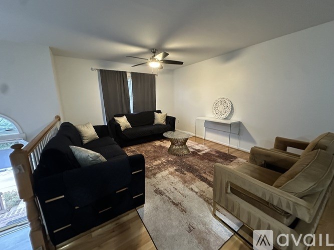 A living room with a black couch and a brown armchair.