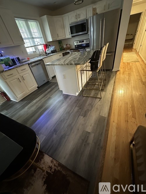 A kitchen with white cabinets and a white fridge.