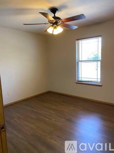 A room with a ceiling fan and a window.