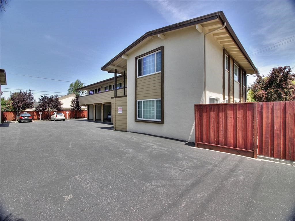 a building with a street in front of it and a wooden fence