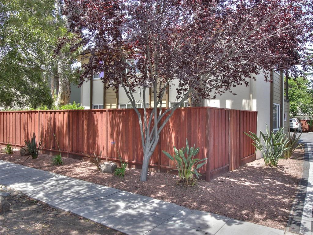 a wooden fence with a tree in front of a house