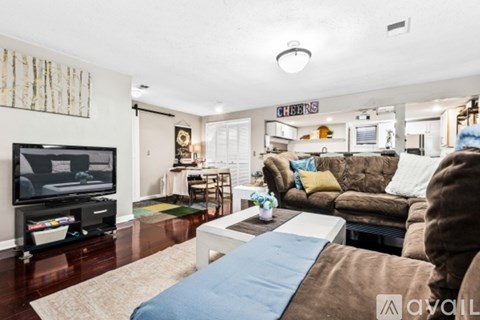 A living room with a brown couch and a flat screen TV.
