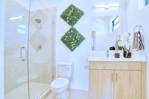 A bathroom with a toilet, sink, and a glass shower stall.
