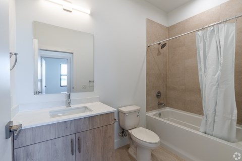 A bathroom with a sink, toilet, and bathtub.