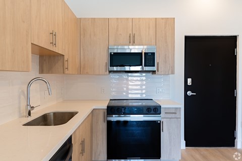 A kitchen with wooden cabinets and a black oven.